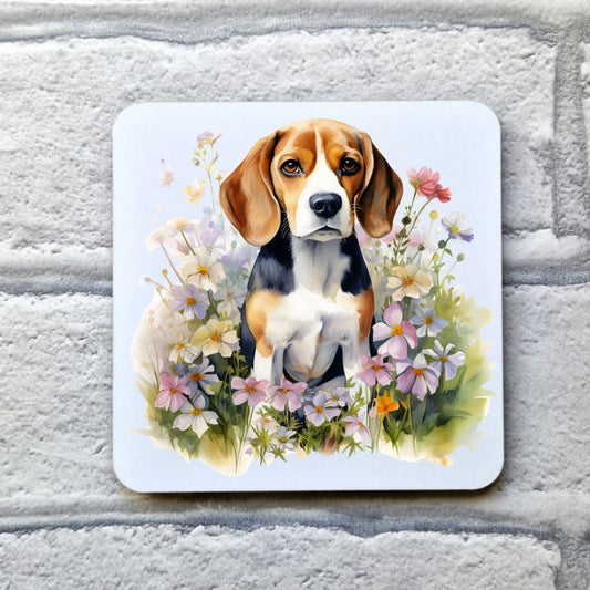 A white coaster with a Beagle dog sat among pink and white spring wildflowers. The coaster is placed on a grey, brick effect surface.