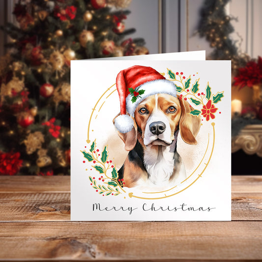 Beagle wearing a Santa hat on a Christmas themed card positioned on a wooden surface in front of a Christmas Tree.