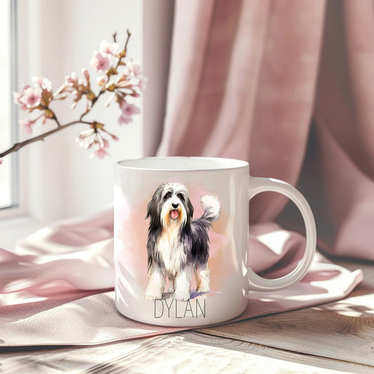 White ceramic mug with a standing Bearded Collie.  Pink draped background. Mug personalised with a pet name.
