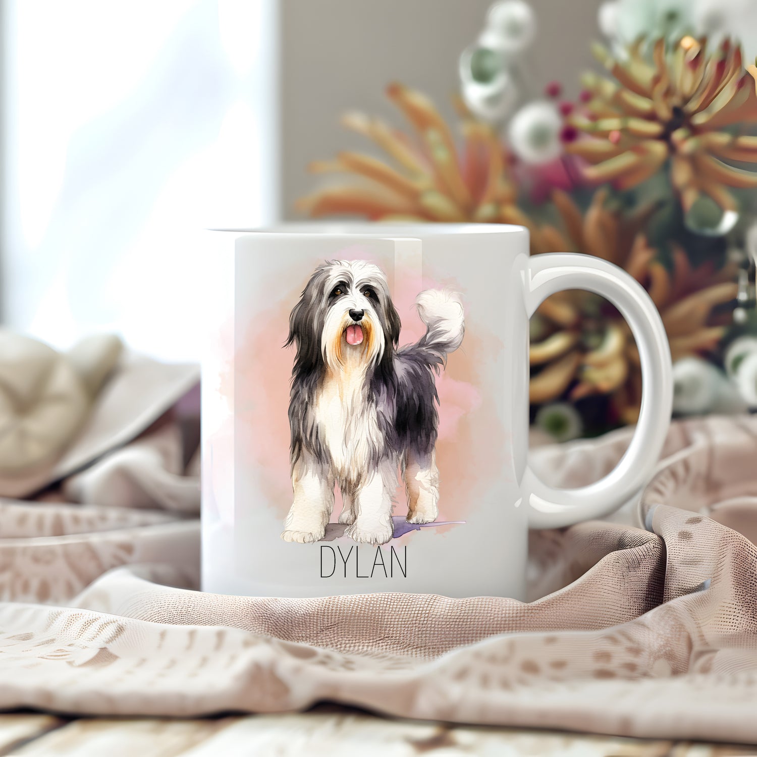 Personalised white ceramic mug.  Image of a lovely Bearded Collie, mouth ope and tongue out. Floral arrangement in the background.