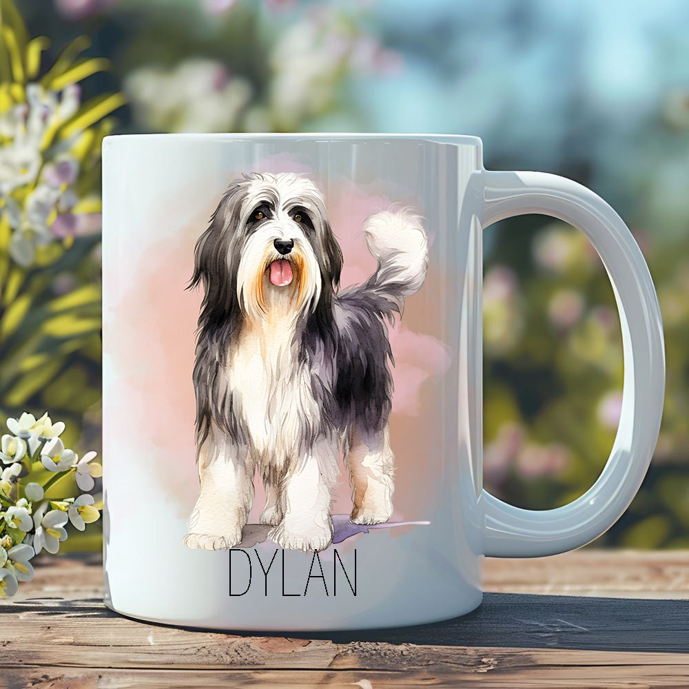 Personalised white ceramic mug adorned with a Bearded Collie dog with it's tongue out.  Mug placed on a wooden surface in a garden scene.
