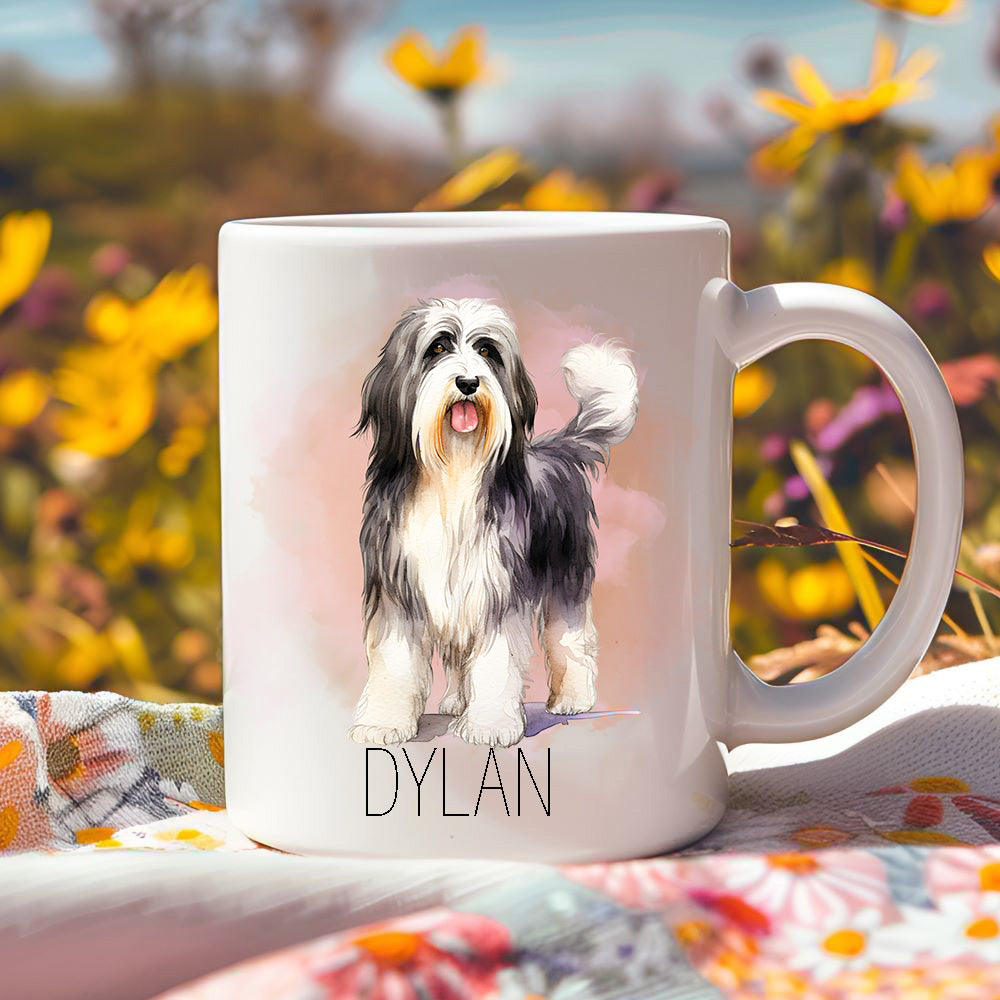 Lovely Bearded Collie mug sat on a floral cloth and vibrant yellow flowers in the background.