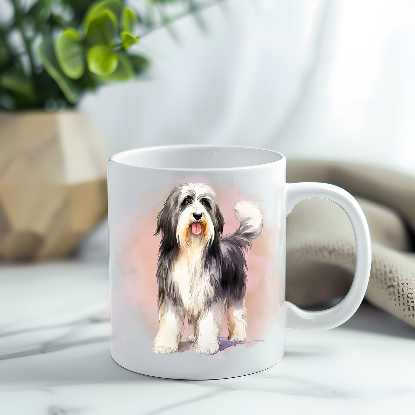 Bearded Collie in a sitting position on a white ceramic mug which has been placed on a grey marble surface.  A plant decorates the left corner.