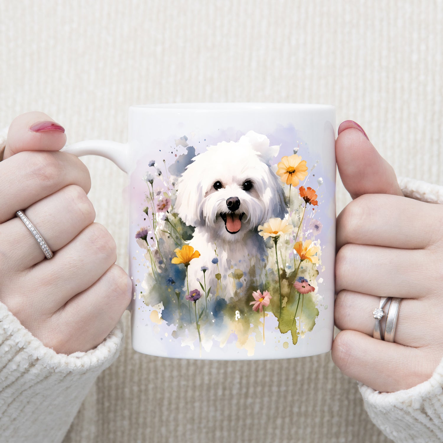 White coffee mug showing a Bichon Frise dog sat amongst wild flowers on a lilac smoky background.