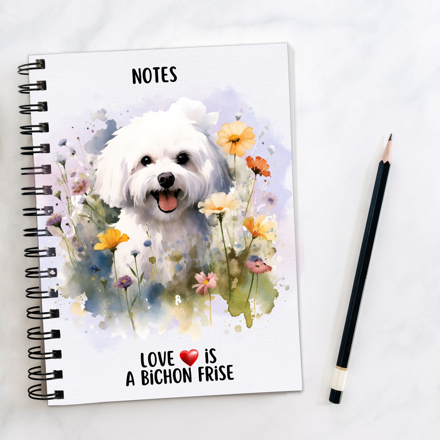 White notebook showing a Bichon Frise dog amongst flowers.  Inscription on the bottom and a pencil to the side.