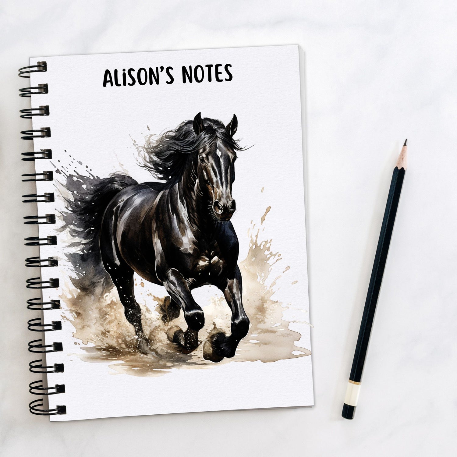 Personalised White notebook showing a Black horse with a white star on its forehead and flowing mane running through water.  A pencil is laid to the side.