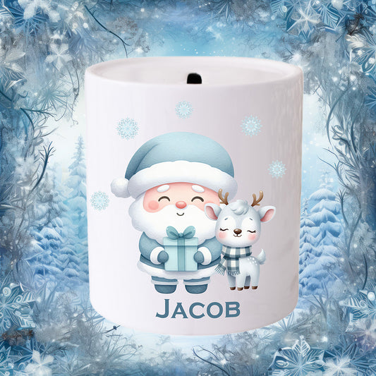 Personalised Christmas money box for a boy.  Santa dressed in blue with a reindeer in a checked scarf.  Winter scene in the background.