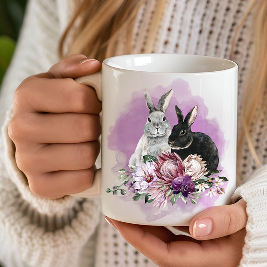 Person holding a mug with rabbit and floral design