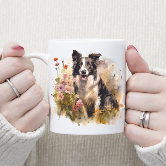 A watercolour image of a black and white Border Collie dog sitting in a bed of flowers. A woman is holding the mug in two hands.