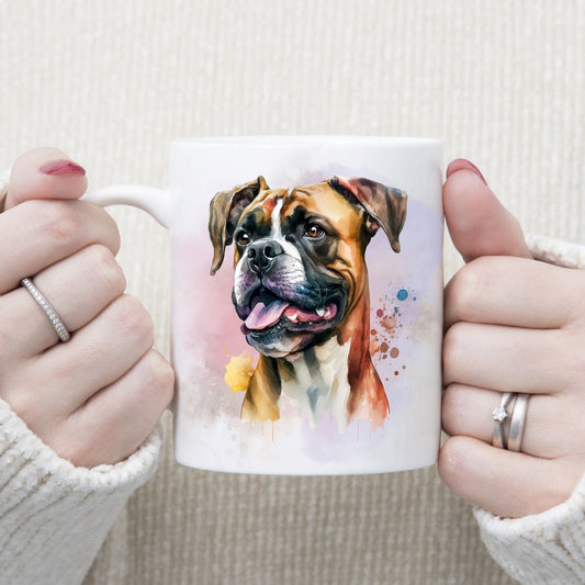 The head of a Boxer dog adorns this white ceramic mug. A pink and lilac smoky effect decorates the background. A woman wearing rings is holding the mug in two hands.