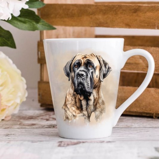 A white ceramic latte mug stands on a wooden surface with a crate in the background. The mug features a Bullmastiff. A large yellow flower peeps in from the left-hand side.