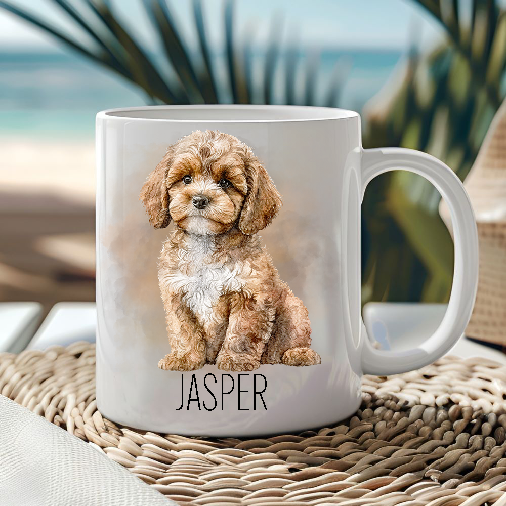 White ceramic mug showing a Cavapoo in a sitting position with a smoke effect background.  Mug is placed on a wicker mat  and a seascape sits behind.