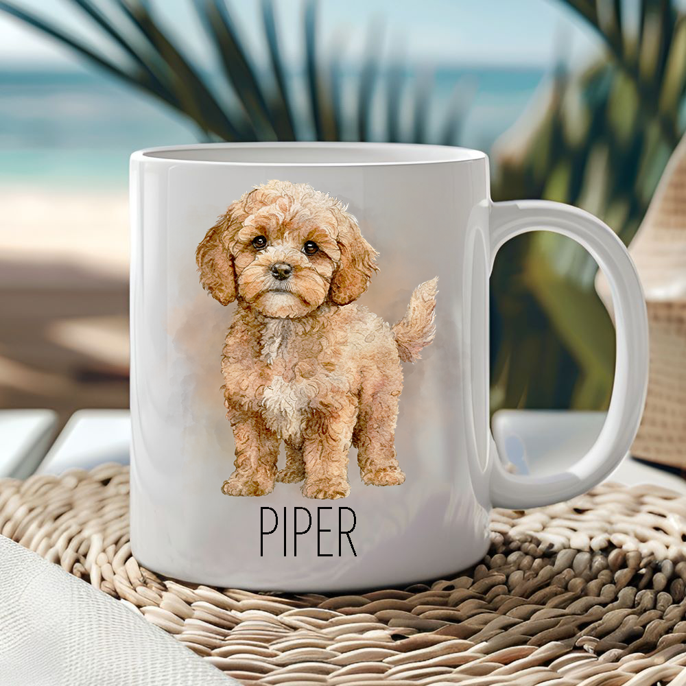 White ceramic mug showing a Cavapoo in a standing position with a smoke effect background.  Mug is placed on a wicker mat  and a seascape creates the backdrop.