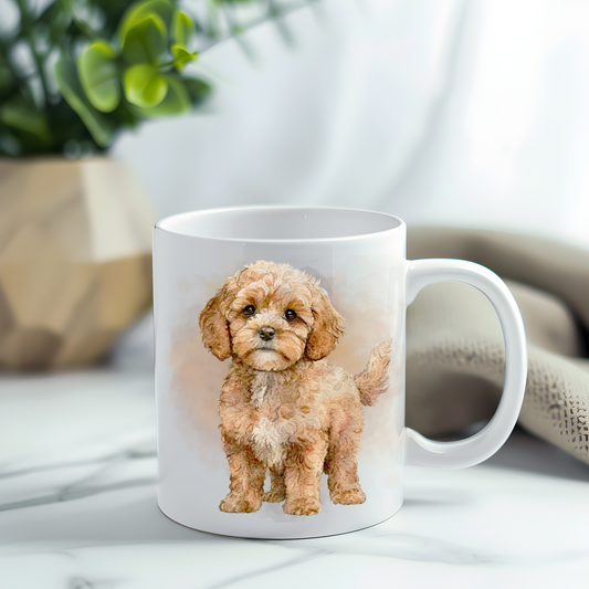 Cavapoo in a standing position looking forward on a white ceramic mug which has been placed on a grey marble surface.  A plant decorates the left corner.