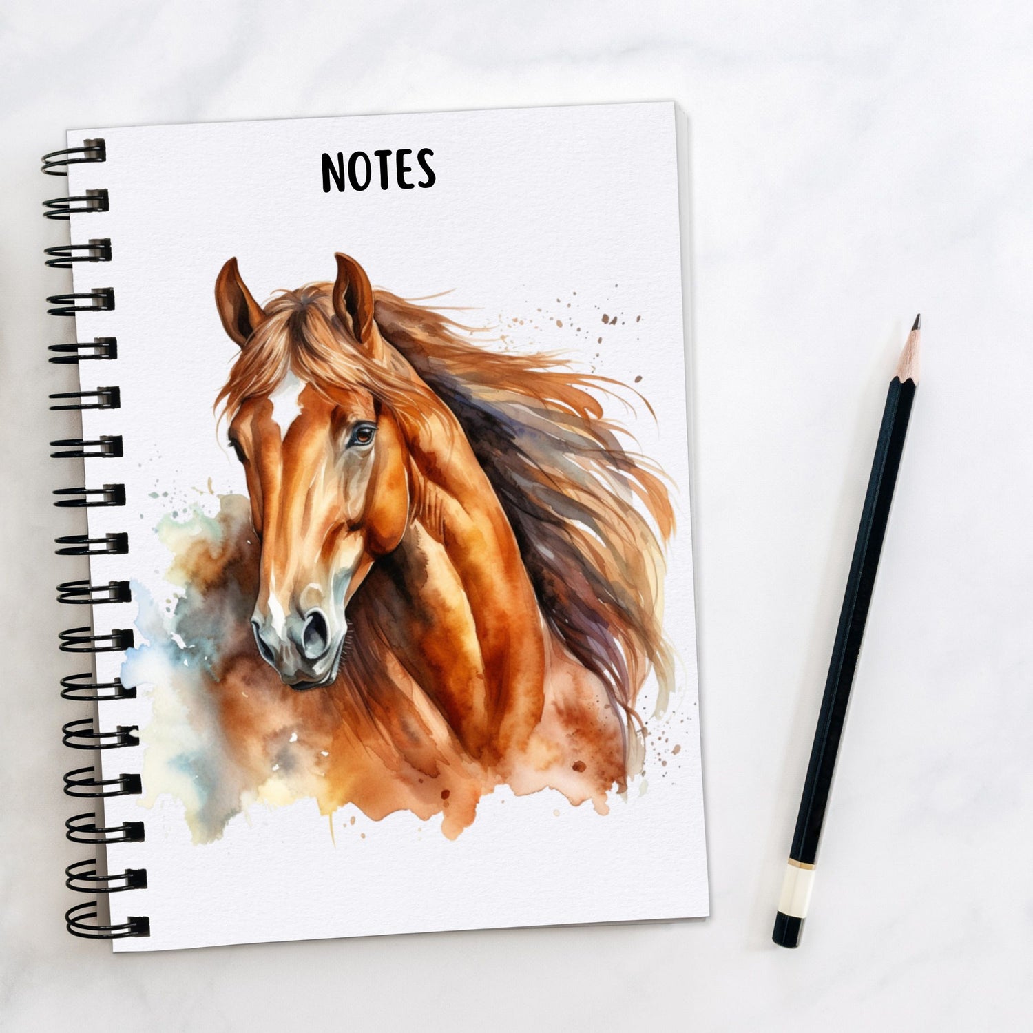 White notebook showing a Chestnut horse with a white star on its forehead and flowing mane.  A pencil is laid to the side.