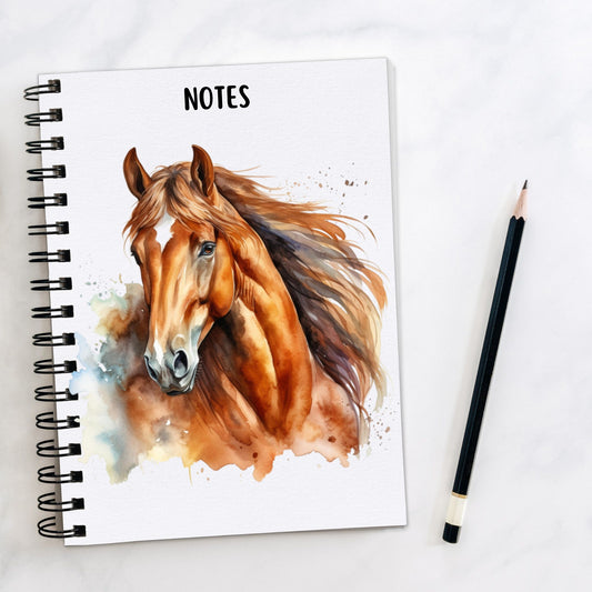 White notebook showing a Chestnut horse with a white star on its forehead and flowing mane.  A pencil is laid to the side.