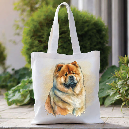 White tote bag with a long handle showing a Chow Chow dog sitting in front of a gold coloured background. The bag is placed in front of a large green shrub with green foliage to the right side.