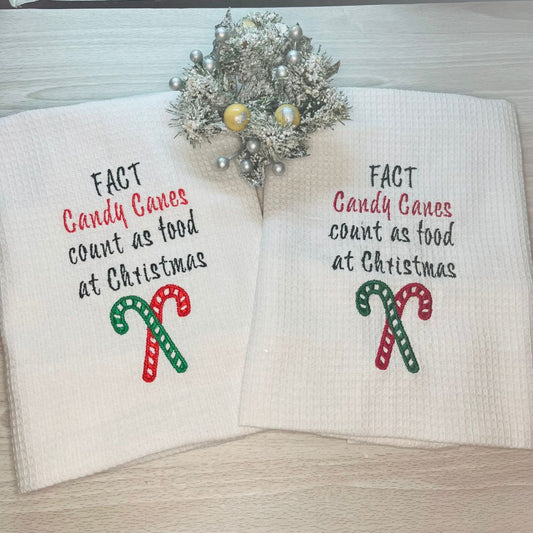 Image of Christmas tea towels with the slogan candy canes count as food at Christmas