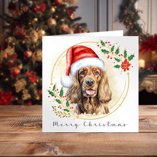 Cocker Spaniel wearing a Santa hat on a Christmas themed card.  Positioned on a wooden surface with a decorated Christmas tree behind.