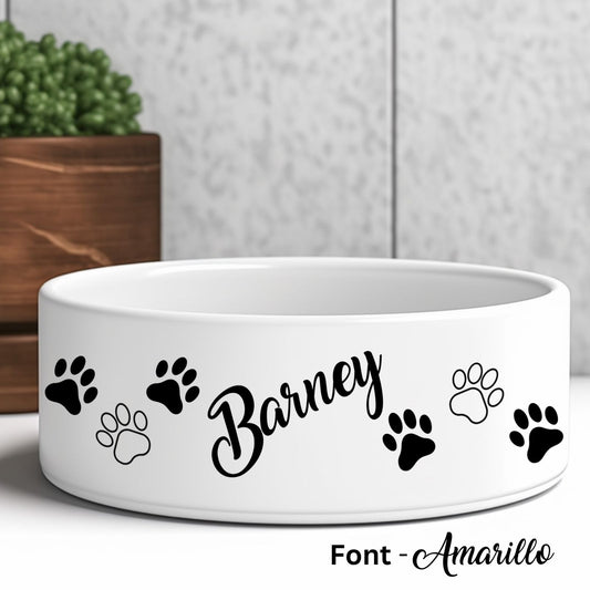 Personalised dog bowl showing a pet's name in a decorative font.  Paw prints decorate both sides of the name.