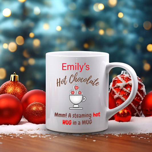 A white ceramic mug with a personalised text and a cartoon illustration, placed on a table with Christmas decorations around, including red and green Christmas balls and a Christmas tree in the background.