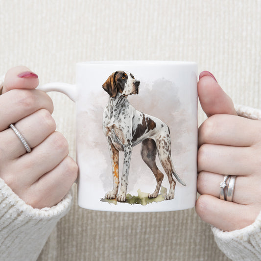 White ceramic mug with an English Pointer stood looking right. A smoky background decorates. The mug is being held by a woman with both hands.