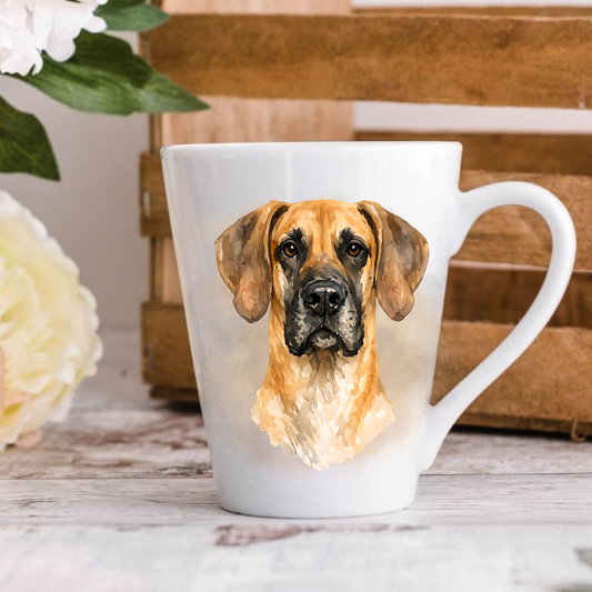 A white ceramic latte mug stands on a wooden surface with a crate in the background. The mug features a Fawn Great Dane.  A large yellow flower peeps in from the left-hand side.