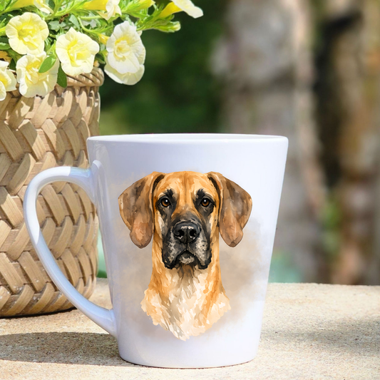 A white ceramic latte mug featuring a Fawn Great Dane in a beige misty background.  A basket containing yellow flowers sits to the left-hand side.