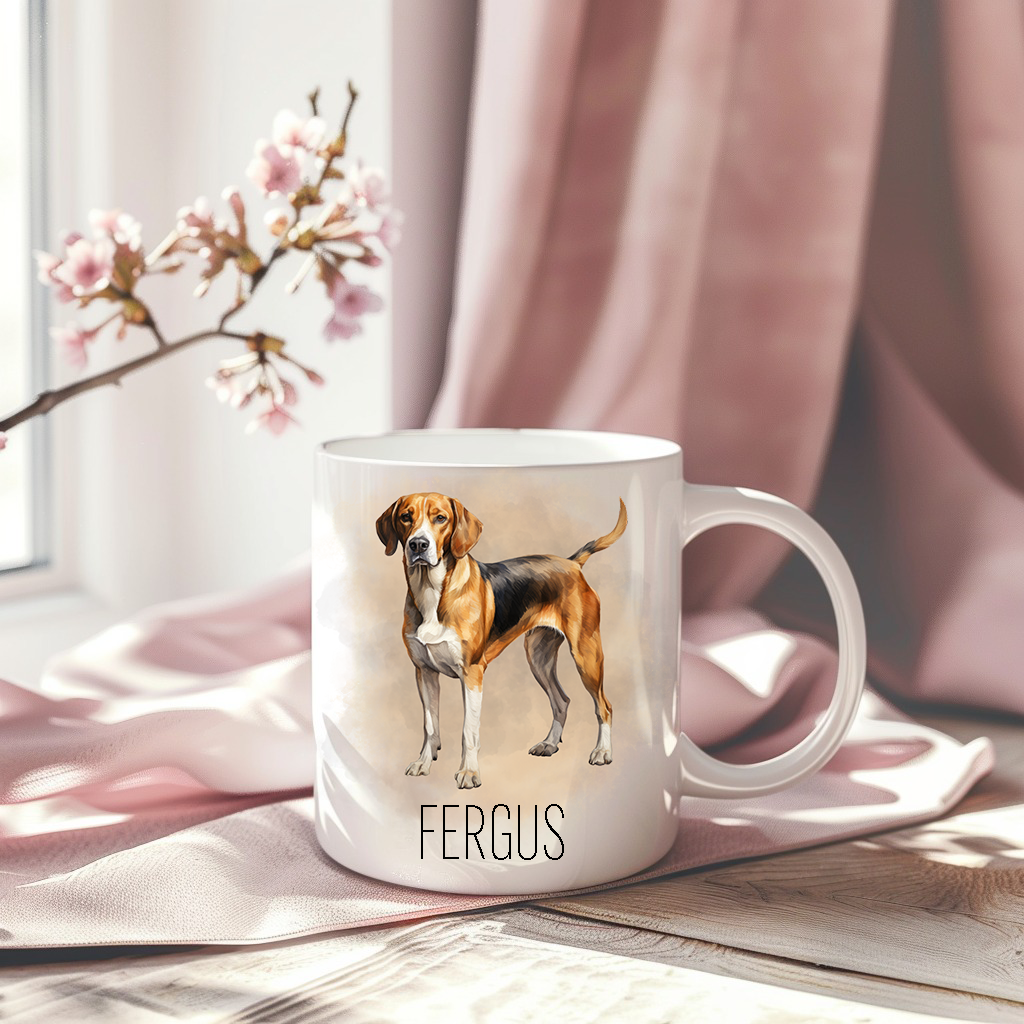 A Foxhound standing with a smoky background on a white ceramic mug which has been placed on a pink drape.  A stem of small pink flowers accessorizes the image.