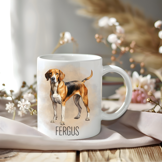 Foxhound coffee mug personalised with a pet name. The mug is sat on a wooden surface with a creamy coloured cloth and various flowers adorn the background.