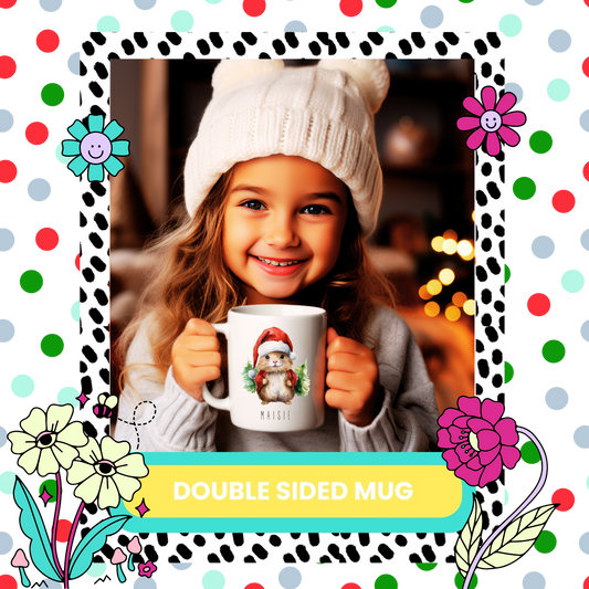 A child holding a double-sided mug with a Christmas theme, featuring a cartoon gerbil character, while smiling and wearing a winter hat.