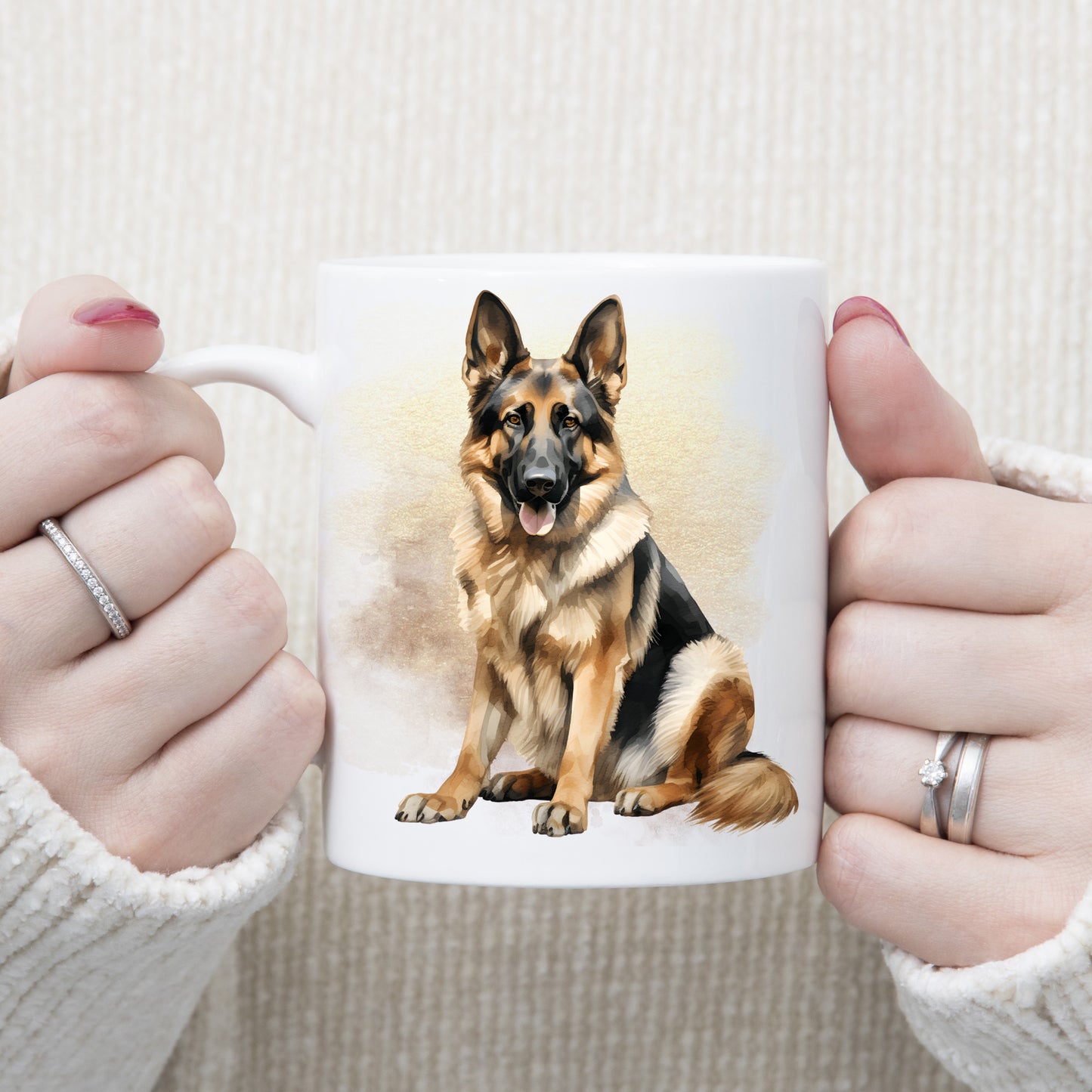 White ceramic mug with a German Shepherd dog sitting.  The mug is being held by a woman with both hands.