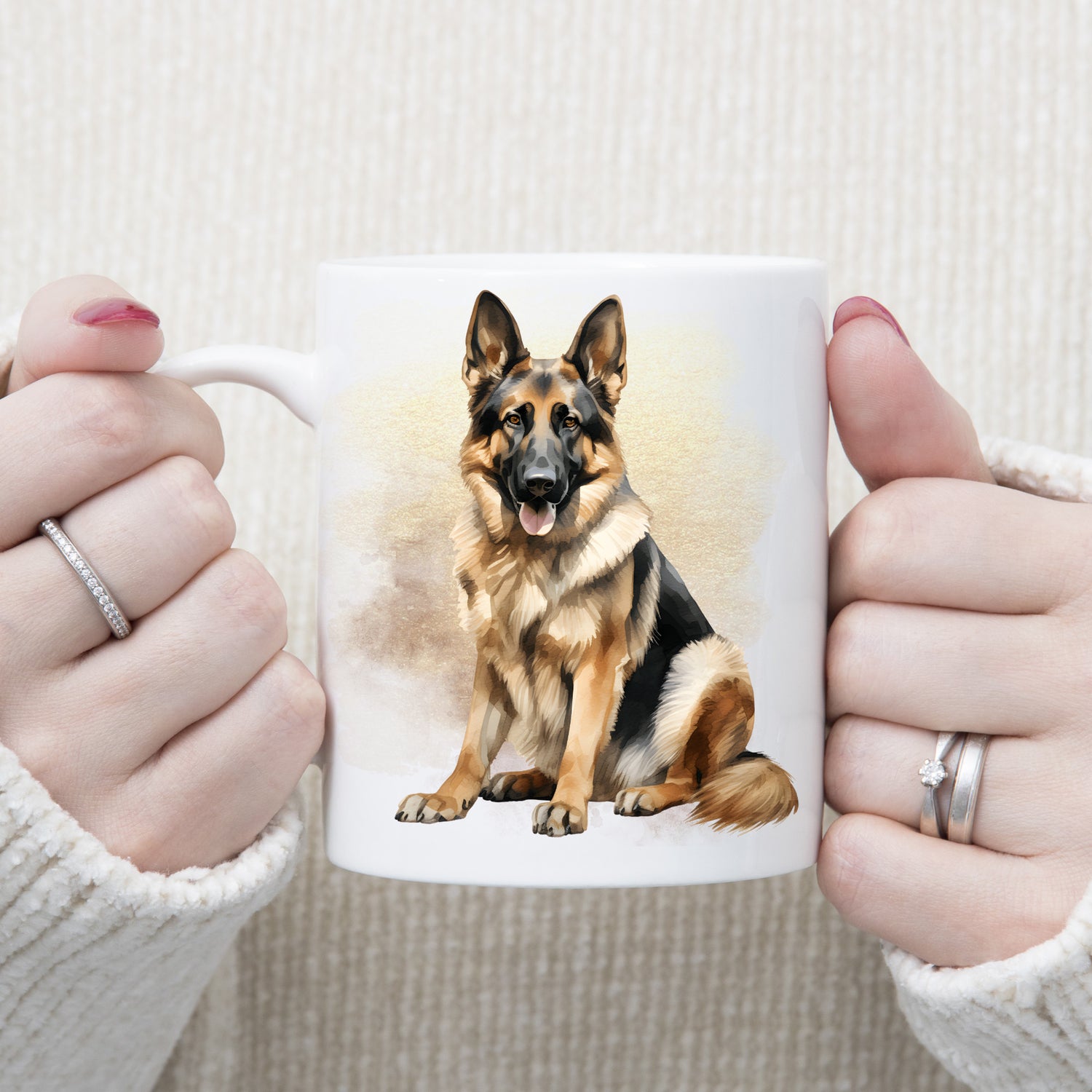 White ceramic mug with a German Shepherd dog sitting.  The mug is being held by a woman with both hands.