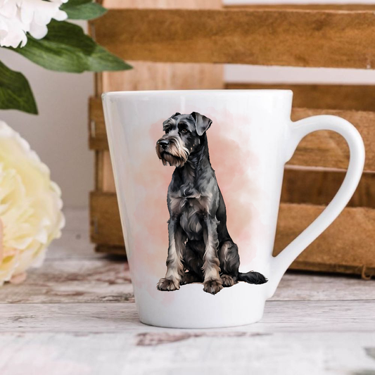 A white ceramic latte mug stands on a wooden surface with a crate in the background. The mug features a Giant Schnauzer dog. A large yellow flower peeps in from the left-hand side.