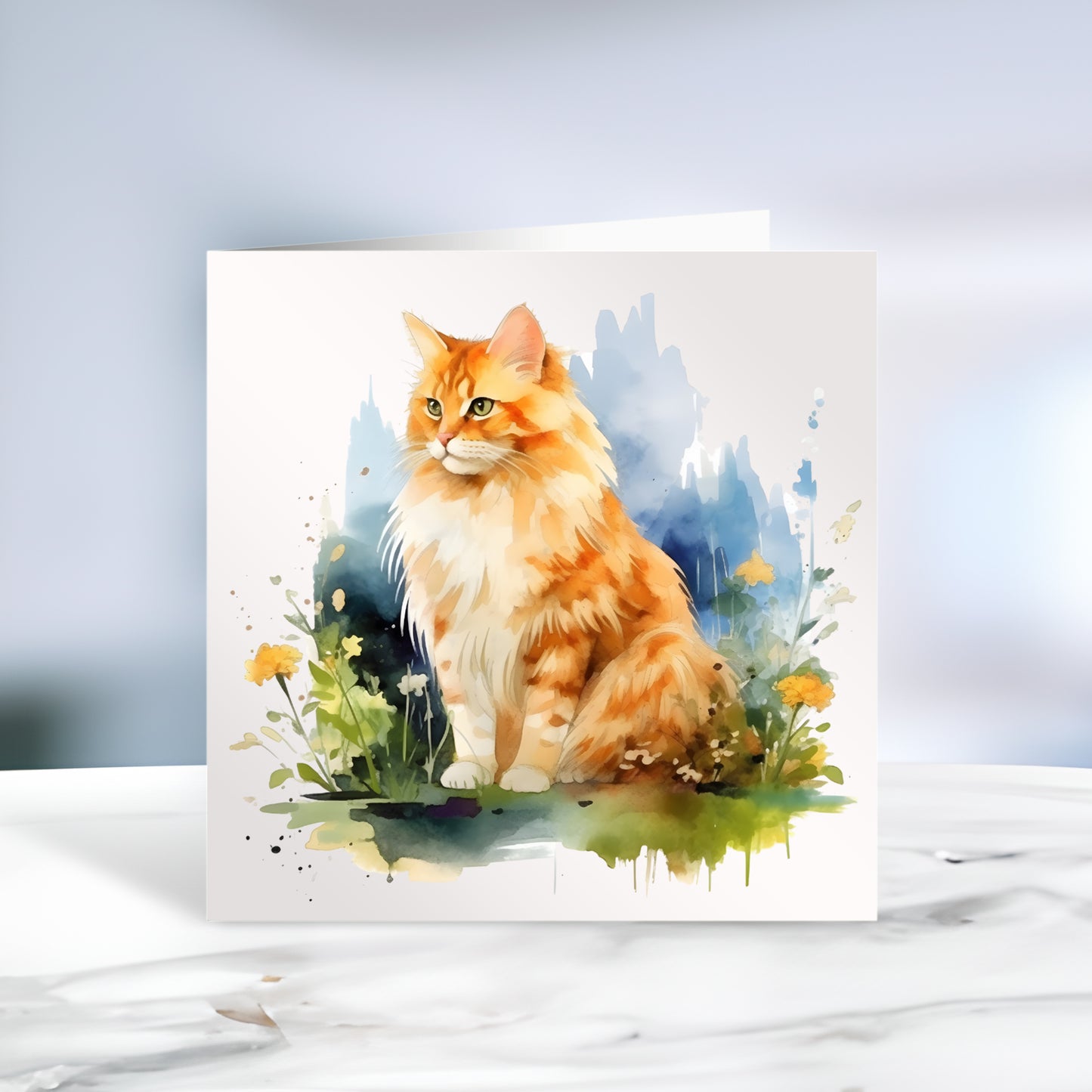 Long haired Ginger cat sat among orange flowers and a blue background on a white card. The card is placed on a grey marble surface.
