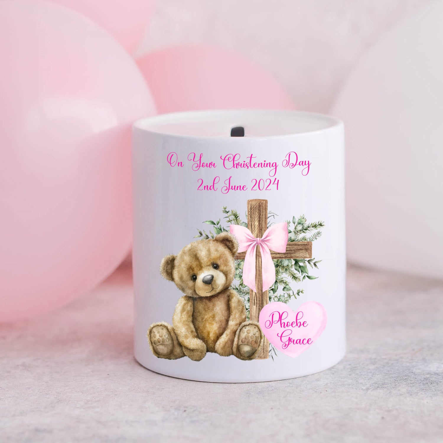 Personalised christening money box for a girl.  Teddy and cross with a pink ribbon and pink balloons in the background.