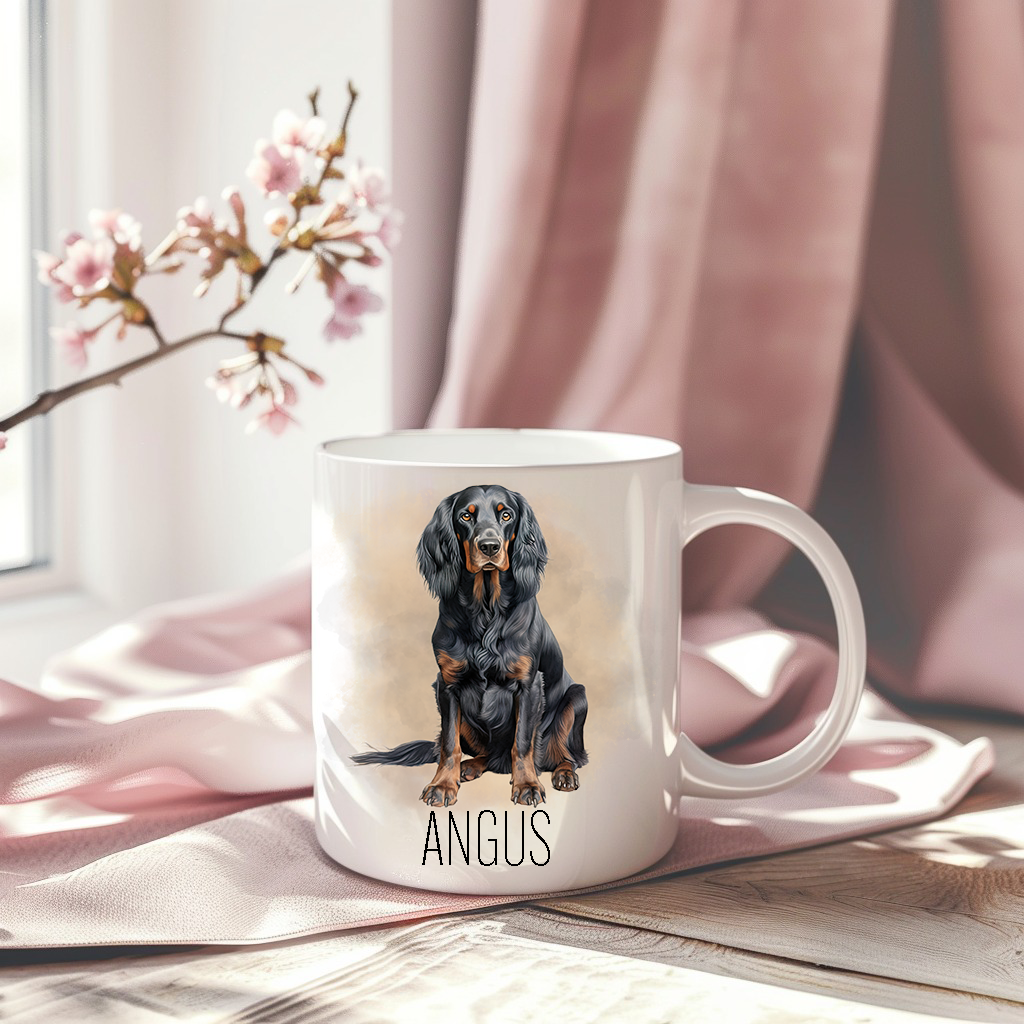 A Gordon Setter in a sitting position on a white ceramic mug which has been placed on a pink drape.  The mug is personalised and a stem of small pink flowers accessorizes the image.