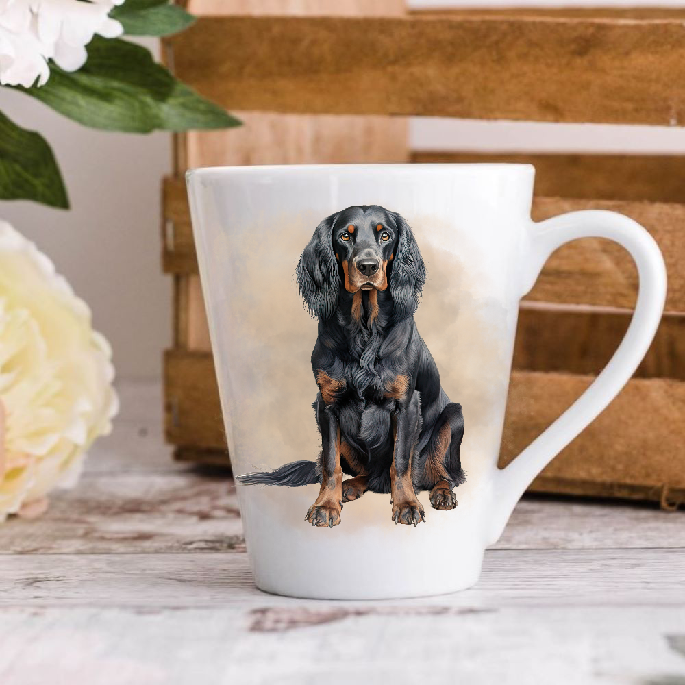 A white ceramic latte mug stands on a wooden surface with a crate in the background. The mug features a Gordon Setter.  A large yellow flower peeps in from the left-hand side.