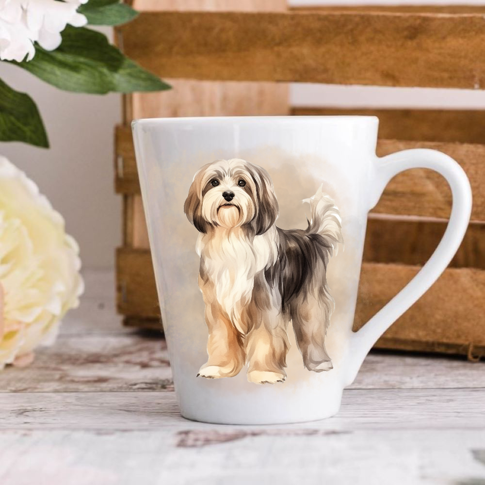 A white ceramic latte mug stands on a wooden surface with a crate in the background. The mug features a cute Havanese dog.  A large yellow flower peeps in from the left-hand side.