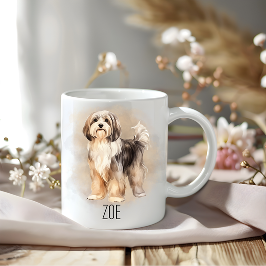 A Havanese coffee mug personalised with a pet name. The mug is sat on a wooden surface with a creamy coloured cloth and various flowers adorn the background.