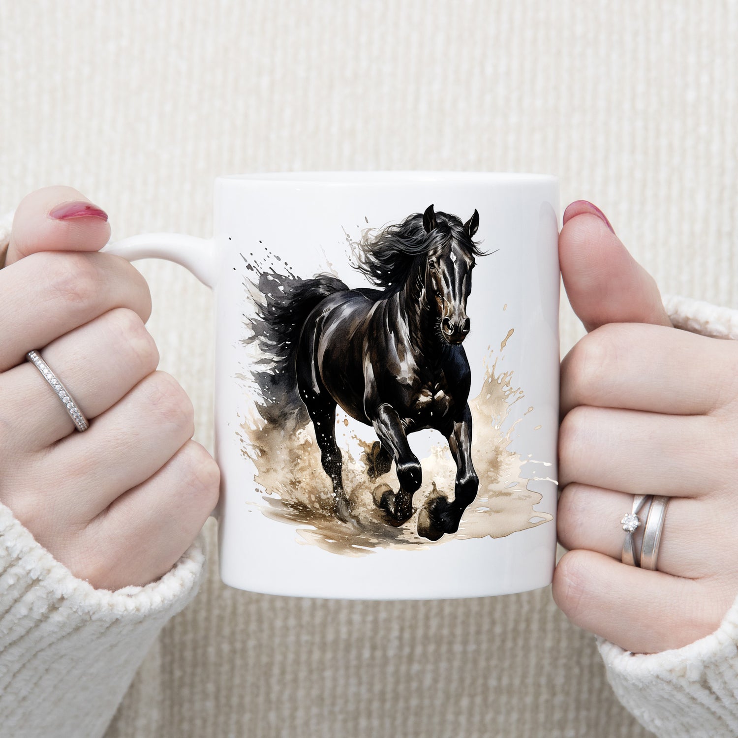 Black stallion horse running through muddy water.  Image on a white ceramic mug being held with both hands by a woman.