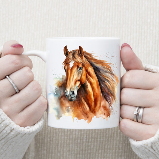 A head and shoulder watercolour image of a chestnut horse with a long flowing mane and is set on a white ceramic mug being held with both hands by a woman.