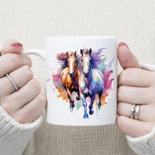 Two horses running with a multi-coloured background. Image on a white ceramic mug being held with both hands by a woman.