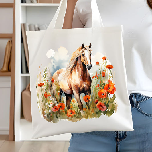 White tote bag with a long handle showing a light coloured horse in a field of poppies. A woman is holding the bag in front of white book case.