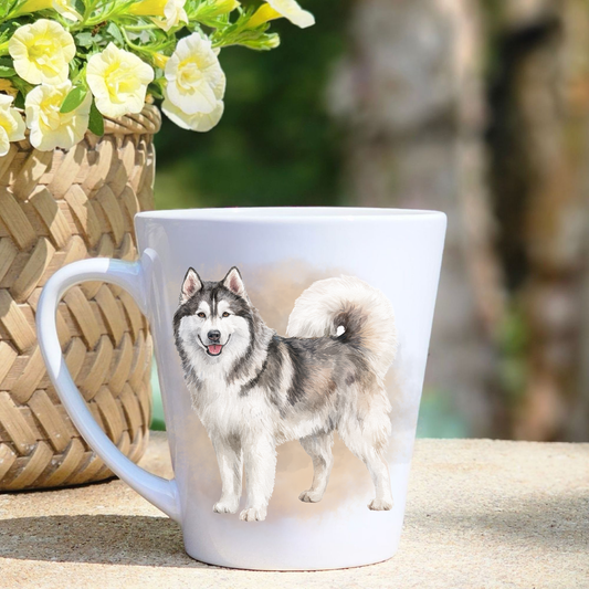 A white ceramic latte mug featuring a standing Husky in a brown/gold mist background.  A basket containing yellow flowers sits to the left-hand side.