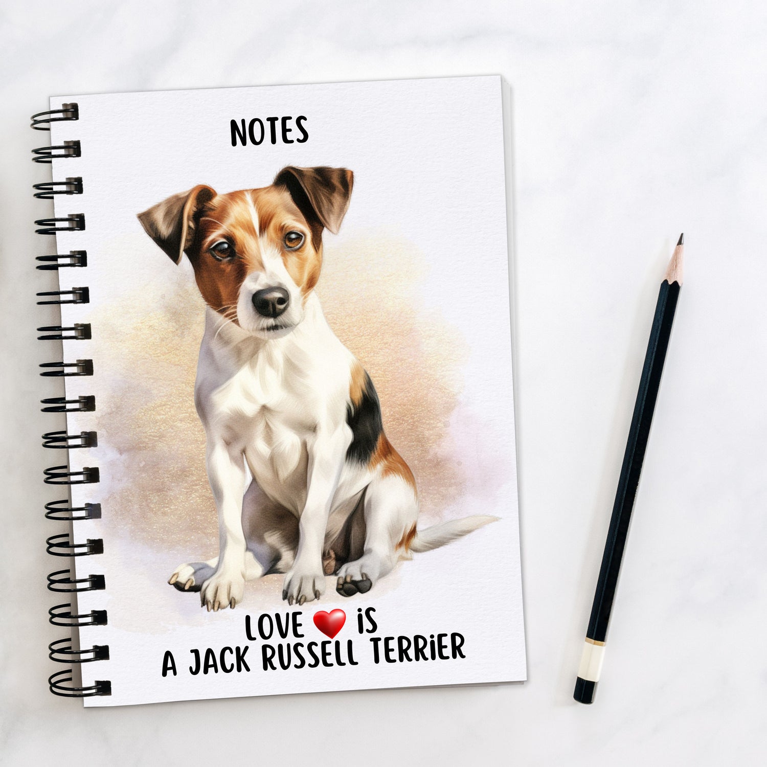 A5 white notebook with black spiral wire binding.  A Jack Russell Terrier sits  on the front cover.  A golden brown background decorates and a black pencil is placed to the right hand side.  A quote with a red heart is placed at the bottom of the book.