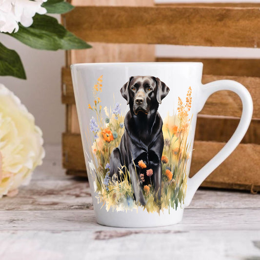 A 12oz white ceramic latte mug with a printed image of a black Labrador dog, positioned on a wooden surface with a blurred background.