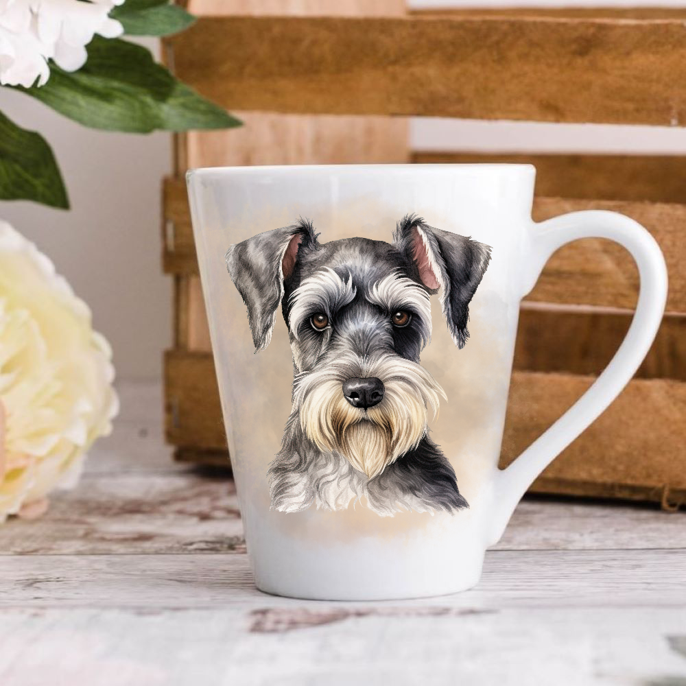 A white ceramic latte mug stands on a wooden surface with a crate in the background. The mug features a Miniature Schnauzer dog.  A large yellow flower peeps in from the left-hand side.