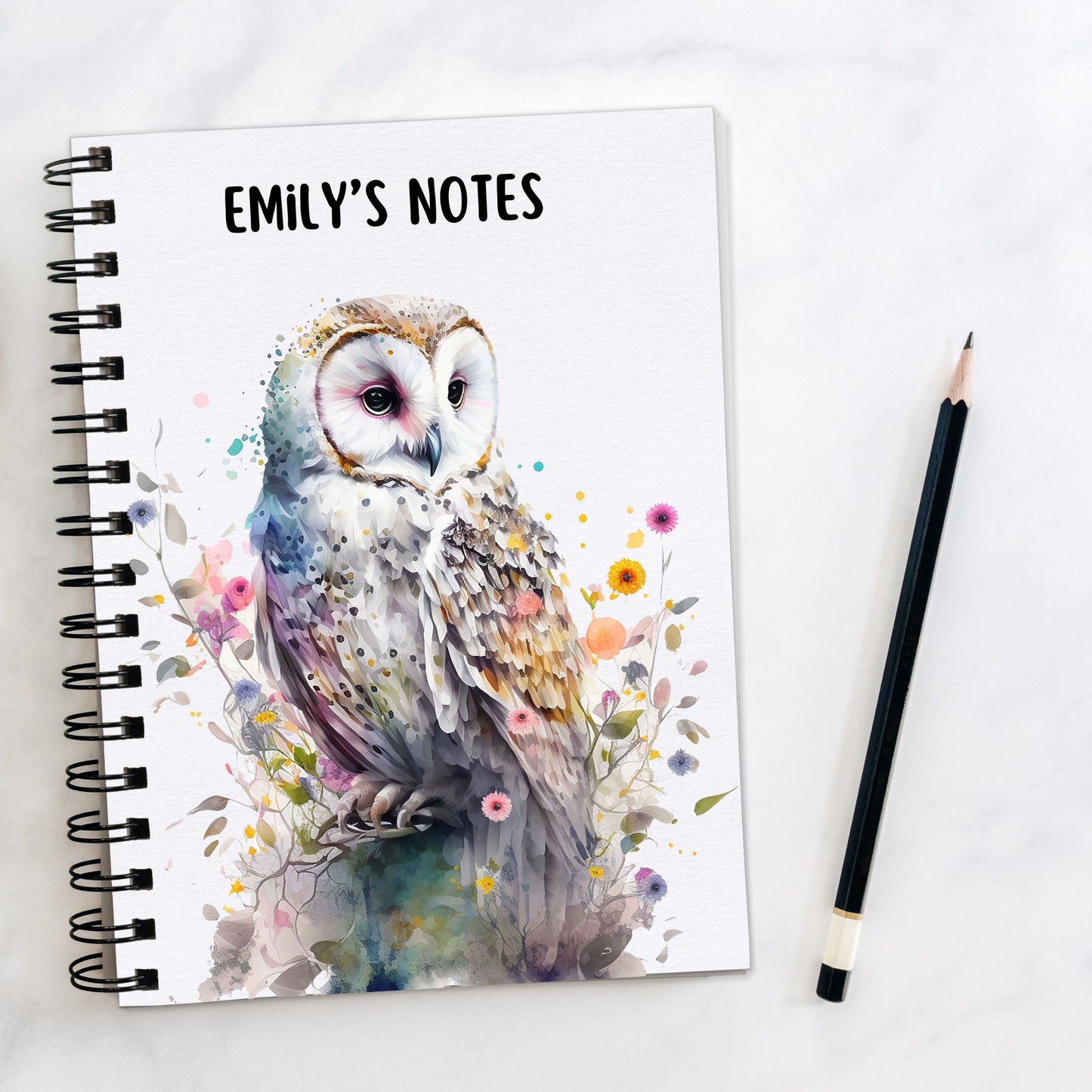 Personalised white spiral bound notebook, with a colourful Barn Owl perched among pastel colour flowers. A pencil is laid to the side.