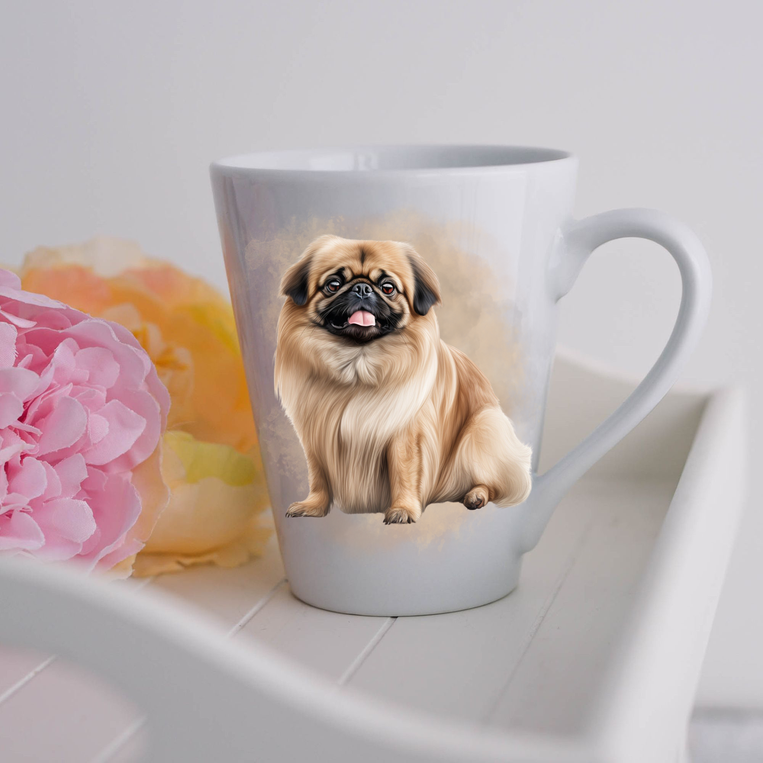 A Pekingese dog is shown sitting on a white ceramic latte mug in a smoky background and looking forward.  The mug is placed on a white tray with pink and yellow flowers